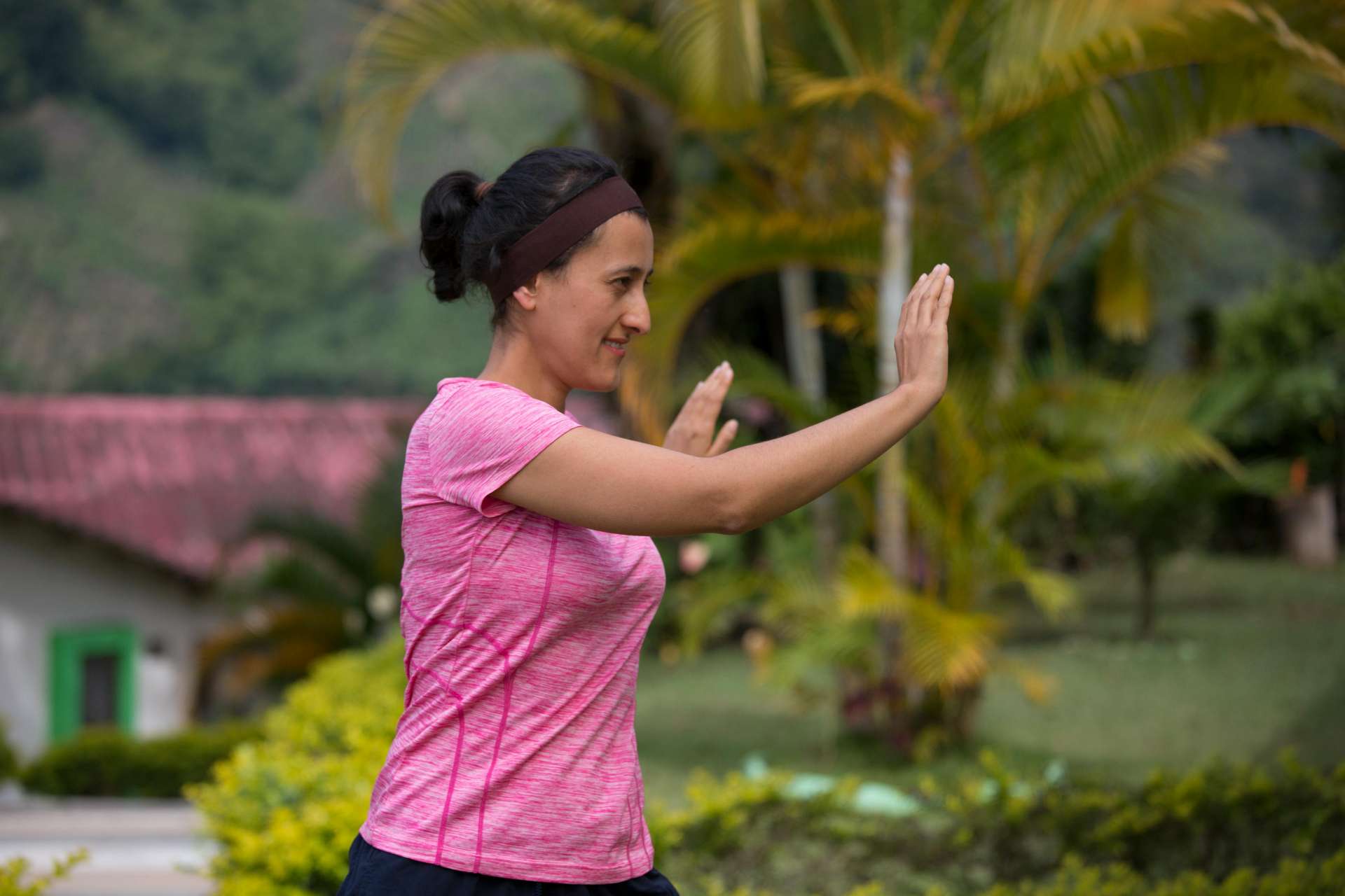 People practicing tai chi in a field surrounded by trees